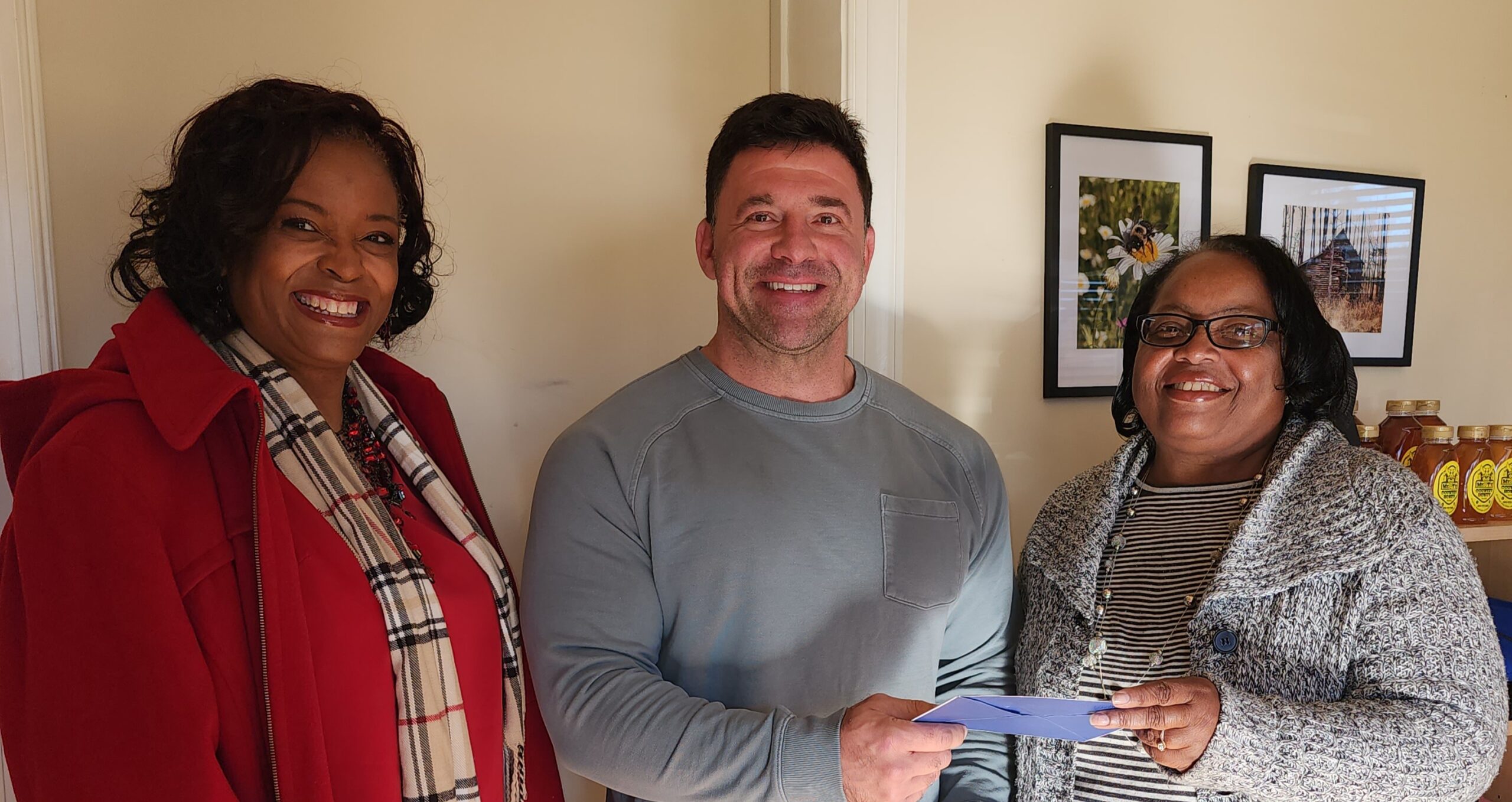 Rachel Brown and Alfredia Lee presenting Brian Daniel with a collaborative donation for the Angel Tree Prison Fellowship Ministry