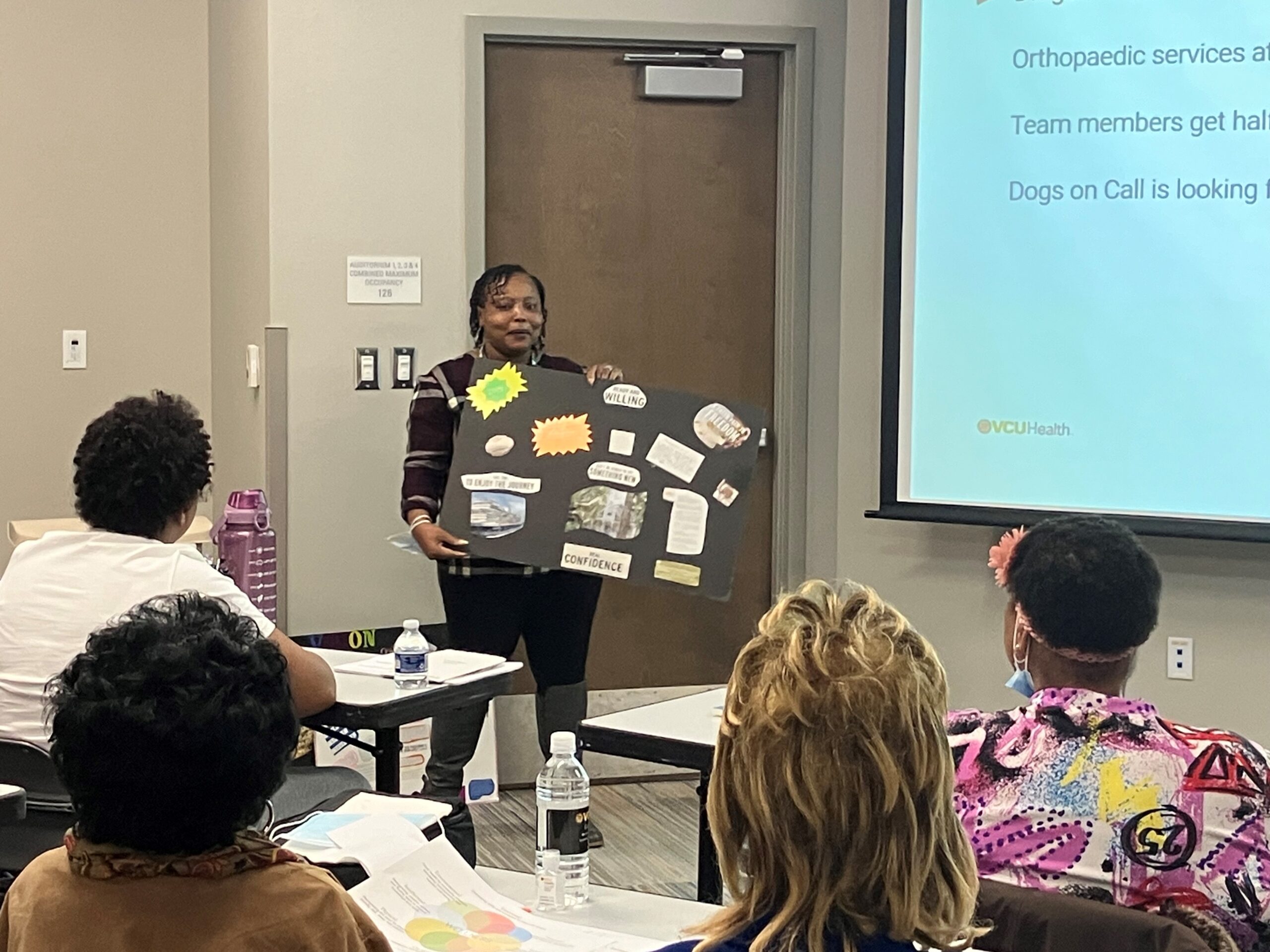 Vice President of Public Relations, LaTonja Harris, shows her previous year's vision board and explains the value of words at the "Visioning a Healthier 2024" event.